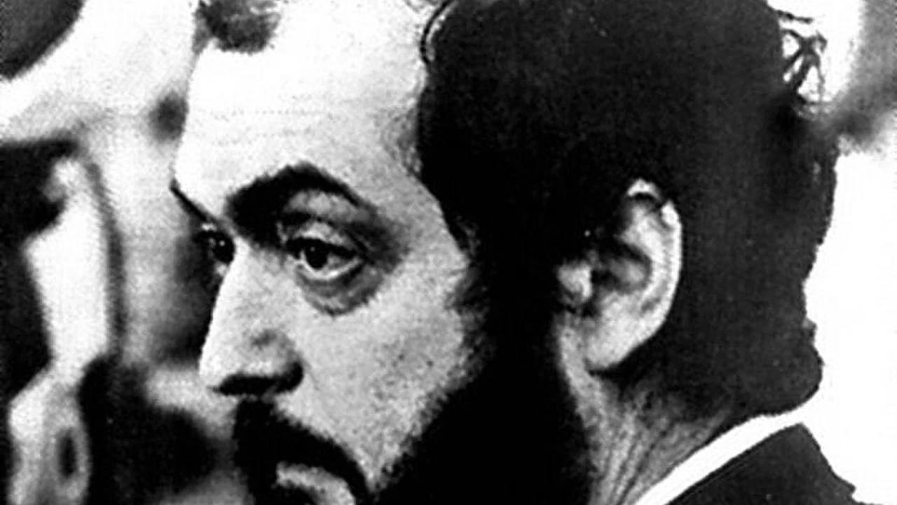 Stanley Kubrick in profile, bearded, on the set of Barry Lyndon, in black and white.